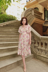a lady in a pink floral printed silk dress